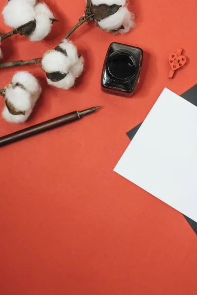 Set of vintage dip pen, inkpot and blank paper sheet with envelope on red, Valentines day concept