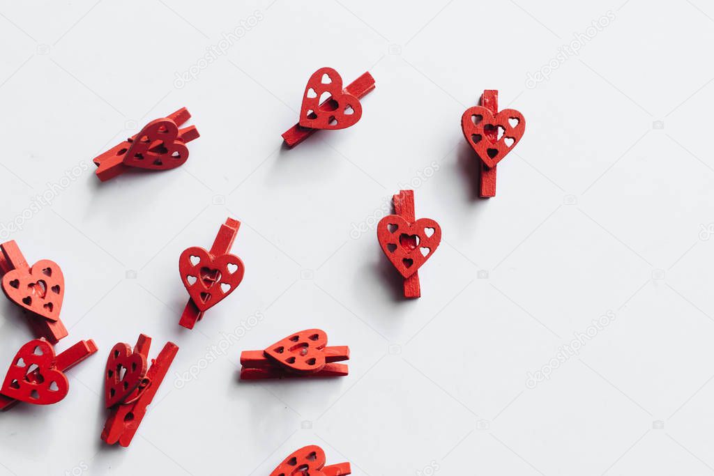 pile of scattered red clothes pegs with heart decor isolated on white background