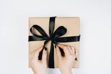 Şerit üzerinde beyaz izole hediye kutusu bağlama kadının kısmi görünümü