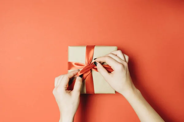 Gedeeltelijke Weergave Van Vrouw Strikken Lint Gift Box Geïsoleerd Rood — Stockfoto
