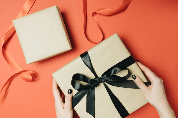 Gedeeltelijke Weergave Van Vrouw Strikken Lint Gift Box Geïsoleerd Rood — Stockfoto