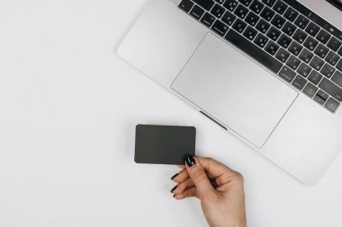Kredi kartı tutan ve dizüstü bilgisayar kullanan eller. İnternetten alışveriş 