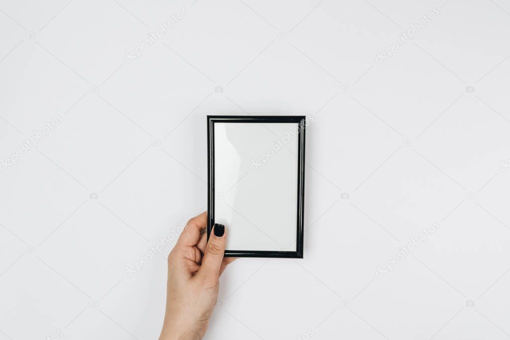woman holding a blank frame on a white background