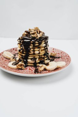 Çikolata soslu, cevizli ve dilimlenmiş muzlu ev yapımı leziz krepler.