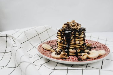 Çikolata soslu, cevizli ve dilimlenmiş muzlu ev yapımı leziz krepler.
