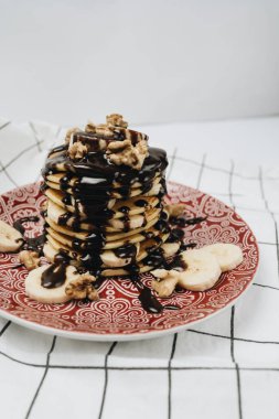 Çikolata soslu, cevizli ve dilimlenmiş muzlu ev yapımı leziz krepler.