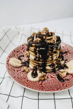 Çikolata soslu, cevizli ve dilimlenmiş muzlu ev yapımı leziz krepler.