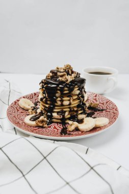 Çikolata soslu, cevizli ve dilimlenmiş muzlu ev yapımı leziz krepler.