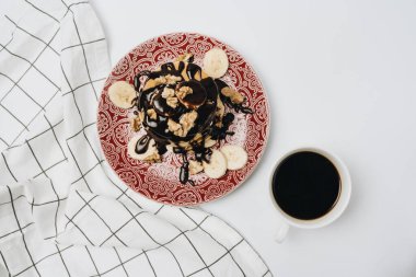 Çikolata soslu, cevizli ve dilimlenmiş muzlu ev yapımı leziz krepler.