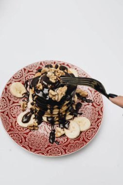 Çikolata soslu, cevizli ve dilimlenmiş muzlu ev yapımı leziz krepler.