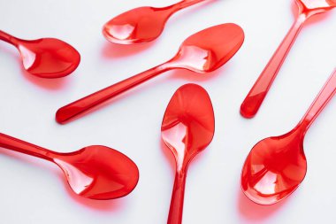 kırmızı plastik kaşık düz beyaz arka planda yatıyordu