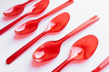 kırmızı plastik kaşık düz beyaz arka planda yatıyordu