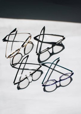 Beyaz arkaplanda satılık gözlükler, yakın plan.