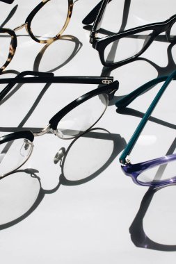 Beyaz arkaplanda satılık gözlükler, yakın plan.