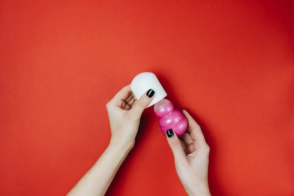 Mano Femenina Sosteniendo Desodorante Rosa Sobre Fondo Rojo Axilas Cuidado — Foto de Stock