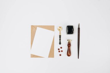 Beyaz zemin üzerinde kalem ve kalem olan boş bir kağıt.