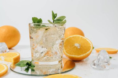 Dilimlenmiş portakallı meyve segmentleri beyaz limonataya izole edilmiş.