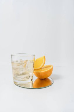 Dilimlenmiş portakallı meyve segmentleri beyaz limonataya izole edilmiş.