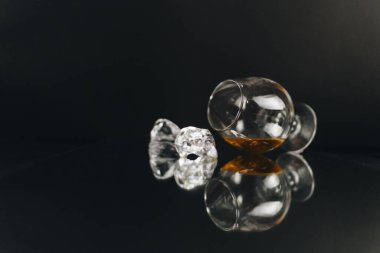 Masada bir bardak viski, konyak ve buz var.