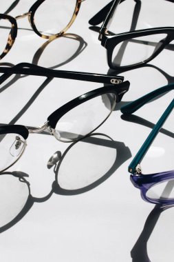 Beyaz arkaplanda satılık gözlükler, yakın plan.