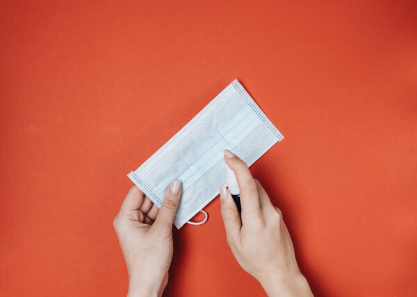Single blue mask for protection against viruses, on red background, covid-19, crown virus, hands protection 