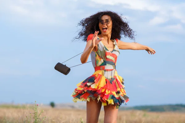 Beautiful brunette woman in a field at sunset — Stock Photo, Image