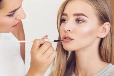 Yeni tarz ile güzel bir model yapmak için profesyonel makyaj sanatçısı