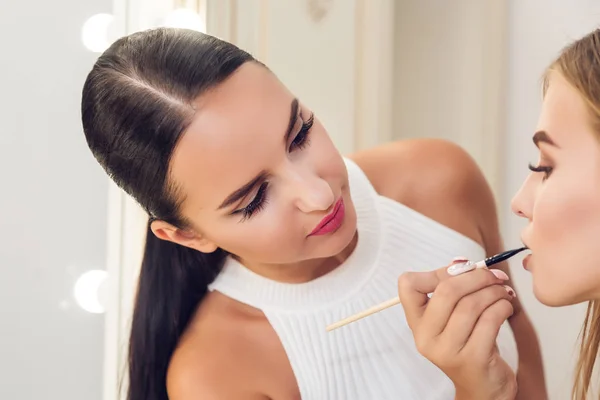 Artista de maquillaje profesional para hacer un nuevo estilo con un hermoso modelo — Foto de Stock