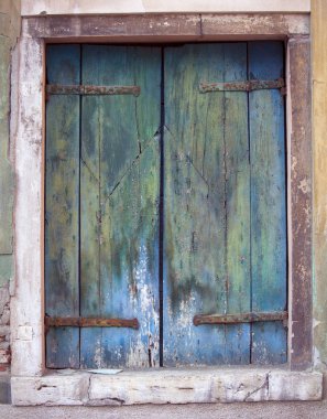 Paslı menteşe ile eski yeşil ve mavi ahşap pencere shuttwes