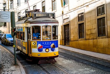 Sarı eski Lizbon tramvayı turistleri şehrin eski bölümlerinde gezdiriyor..