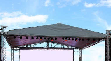 Bir mavi yaz gökyüzü arka plan aydınlatmalı boş konser sahne bölüm