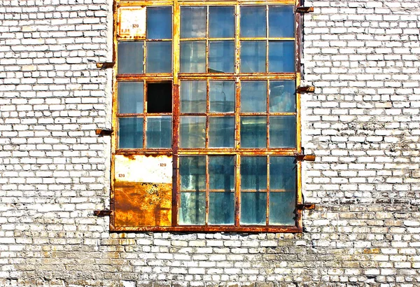 Eski bir binanın duvarına kırık bölmeleri ile eski pencere