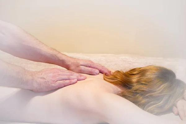 massage of the female back, hands of the masseur of the man, vignette