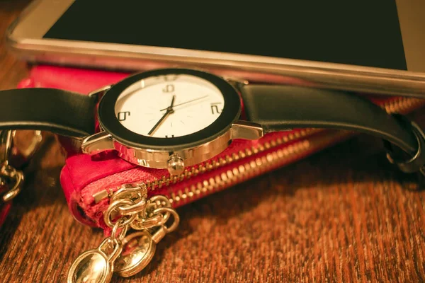 パーソナルな女性用アクセサリー スマートフォン 腕時計 木製のテーブルの上に赤い財布 クローズアップ — ストック写真
