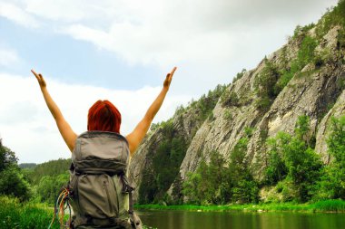 Bekar bir kadın sırt çantasıyla dağlarda geziyor, sağlıklı bir yaşam tarzı.