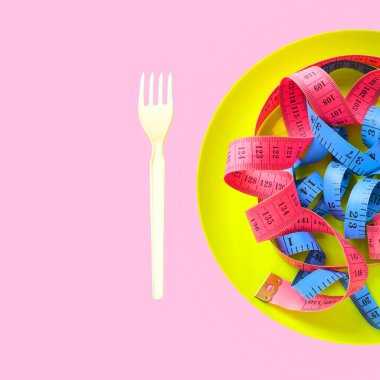 Tabaklardaki renk ölçme bandı, kilo verme konsepti, diyet, sağlıklı yaşam tarzı, pembe arka planda izole edilmiş.