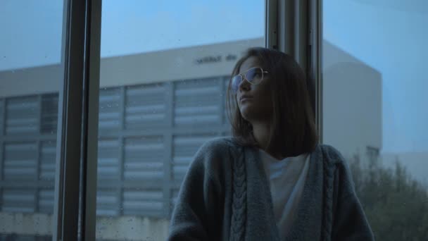 Mädchen Schaut Gelangweilt Aus Dem Fenster Während Regnet — Stockvideo