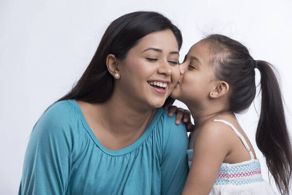 Portrait of daughter kissing mother