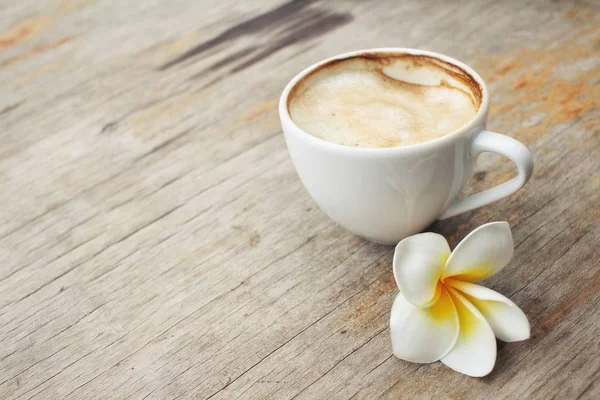 Café con leche y flor de frangipani blanco — Foto de Stock