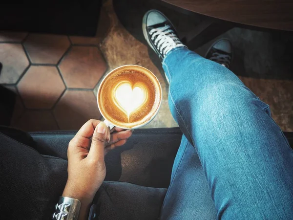 Селфи женщины, пьющей кофе с кроссовками — стоковое фото