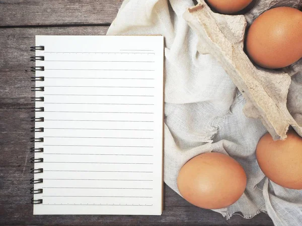 Huevos en caja con bloc de notas en blanco — Foto de Stock