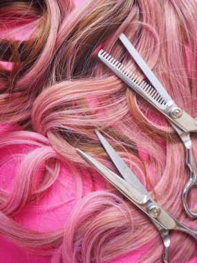 Pembe bir arka plan üzerinde saç kesme makası