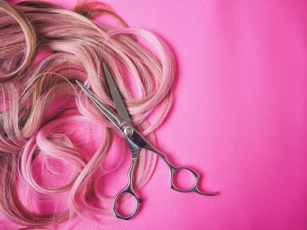 Tesouras de corte de cabelo em fundo rosa — Fotografia de Stock