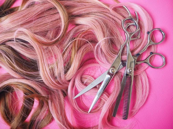 Ножницы для стрижки волос на розовом фоне — стоковое фото