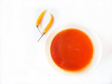 üstten görünüm sriracha chili sos ve ham biber beyaz izole kase