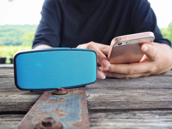 Mulher usando alto-falante Bluetooth com telefone inteligente — Fotografia de Stock