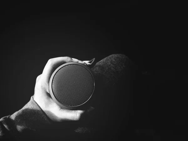black and white cropped shot of woman holding bluetooth speaker