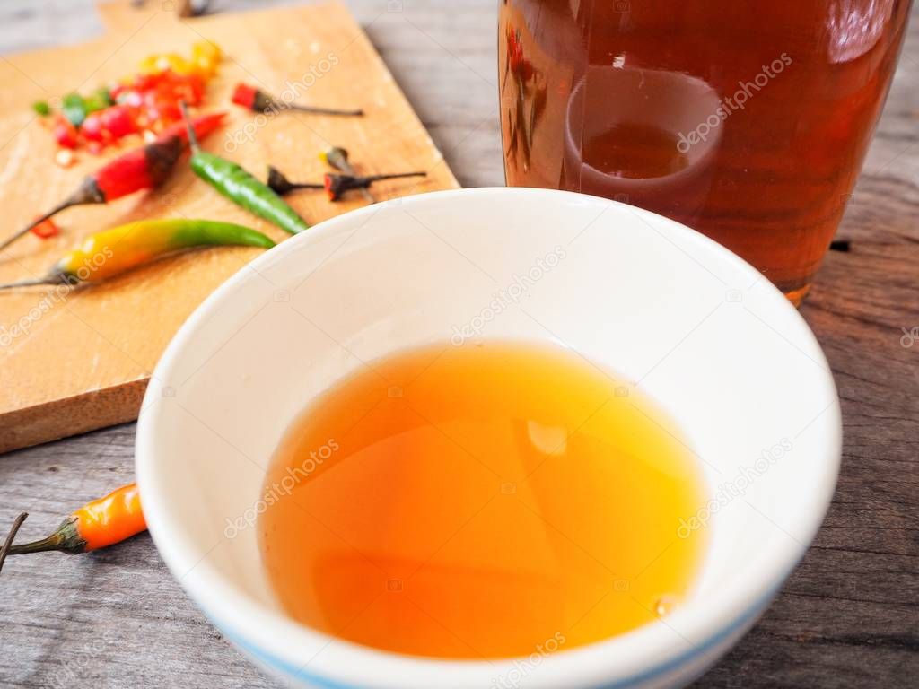 Fresh tasty fish sauce with chili on wooden background