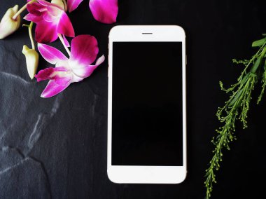 Siyah arka plan üzerine pembe taze orkide çiçekli Beyaz smartphone