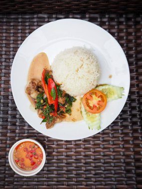 Beyaz tabakta Tay fesleğen domuz pirinç ve balık sosu ile